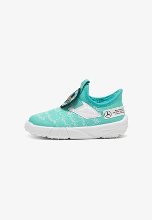 Türkiz slip-on sportcipők fehér részletekkel. Texturált felszínnel és mintázattal rendelkeznek, elasztikus pánttal és logórészlettel az oldalukon.
