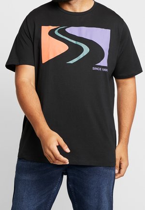 Man wearing black t-shirt with abstract curved road design in orange, teal, and purple, and text "SINCE 1990" on front.