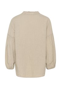 Beige vászonblúz kerek nyakkivágással, rugalmas puffujjakkal és enyhén laza fazonnal. A textúra lágy és légáteresztő.