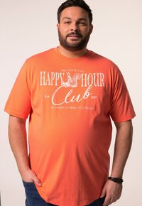 Oranžové bavlněné tričko s krátkými rukávy, na kterém je bílý potisk s textem "HAPPY HOUR Club Est. 2007" a grafikou nápoje.
