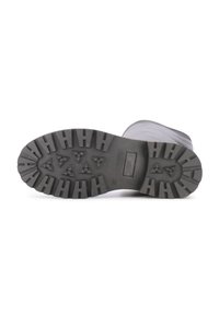 Black rubber boot sole with a rugged tread pattern. Features deep grooves and star-shaped indentations for traction. Size marked as 37.