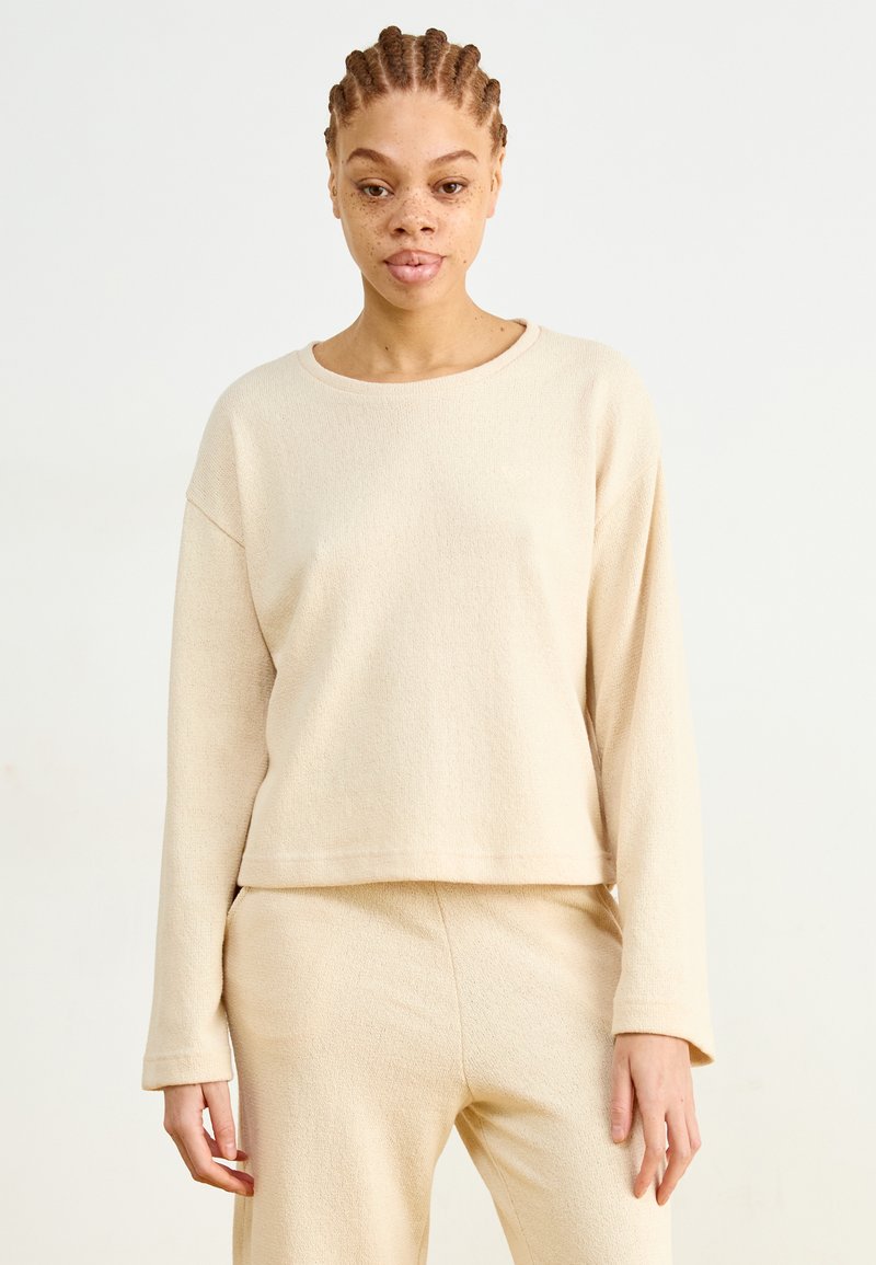 Beige lange mouw top van textiel met structuur, met een wijde halslijn en een ontspannen pasvorm, gecombineerd met bijpassende beige broek.