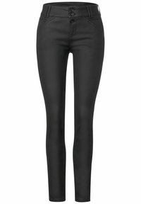 Jeans skinny noirs en tissu lisse. Présentent une taille haute, deux poches avant et une fermeture à double bouton avec passants de ceinture.