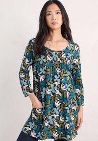 Tunika z długim rękawem z kwiatowym wzorem w kolorach teal, granatowym i zielonym, z okrągłym dekoltem i bocznymi kieszeniami. Miękka tkanina o luźnym kroju.