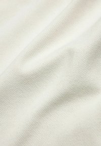 Lichtbeige stof met een gestructureerd oppervlak, met subtiele ribbels en een zachte, gladde uitstraling.