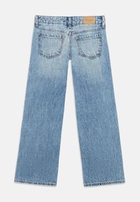 Φαρδιά τζιν από ανοιχτό μπλε denim με ψηλή μέση, κλασικές πίσω τσέπες και δερμάτινη ετικέτα με το λογότυπο στη ζώνη μέσης.