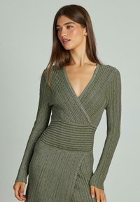 Rochie verde olive, cu mânecă lungă și decolteu adânc în V, având dungi verticale texturate și embellishments subtile pe întreaga suprafață.