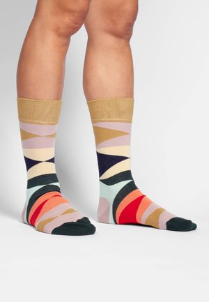 Bunt gestreifte Socken mit geometrischen Mustern in verschiedenen Pink-, Grün-, Marine-, Orange- und Goldtönen, mit einem gerippten goldenen Bündchen oben.