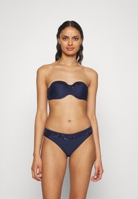 Uten stropper, marineblå bikini topp med rynket front og paljettdekor; kombinert med matchende bunn med midjebånd dekorert med paljetter.