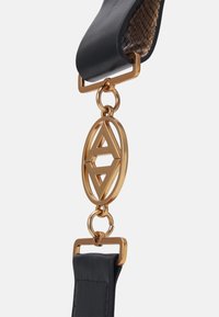 Black leather strap with a gold-tone metal hardware. Features an oval charm with interlocking 'A' design and a textured inner lining.