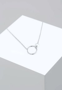 Silver metal necklace featuring a circular pendant and a small disc charm, with a fine chain and polished finish.