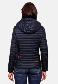 Navy puffer jacket with a hood, featuring horizontal quilted segments and a rubber label detail at the hem. Smooth, glossy material.