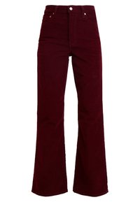 Pantalon évasé en velours côtelé bordeaux avec taille haute, fermeture à bouton et à glissière, et accents de quincaillerie minimalistes. Texture douce.