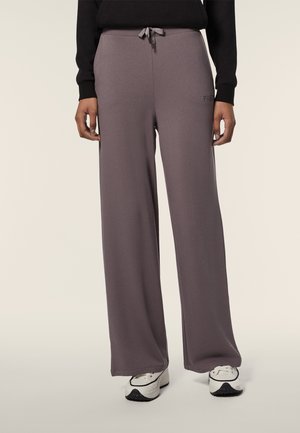Pantaloni sportivi a gamba larga in una tonalità di lavanda tenue. Realizzati in tessuto morbido, con cintura regolabile e dettagli del logo discreti.