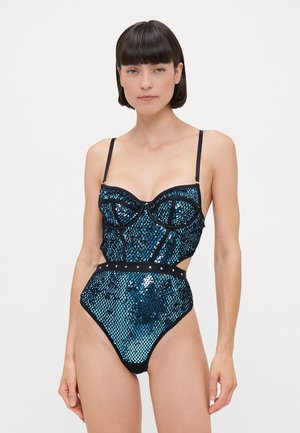 Costume intero con paillettes, dotato di un busto strutturato, spalline nere, lati a taglio e un motivo lucido blu-verde.