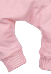 Różowy bawełniany kombinezon dla niemowląt z prążkowanymi mankietami, charakteryzujący się miękką teksturą i luźnym krojem, co pozwala na swobodne ruchy i wygodę.