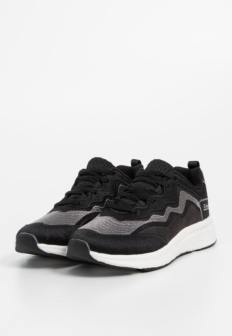 Baskets de sport noires et grises avec une tige en mailles, un tissu texturé, un design incurvé, un embout rond et une semelle intermédiaire blanche. Fermeture à lacets.