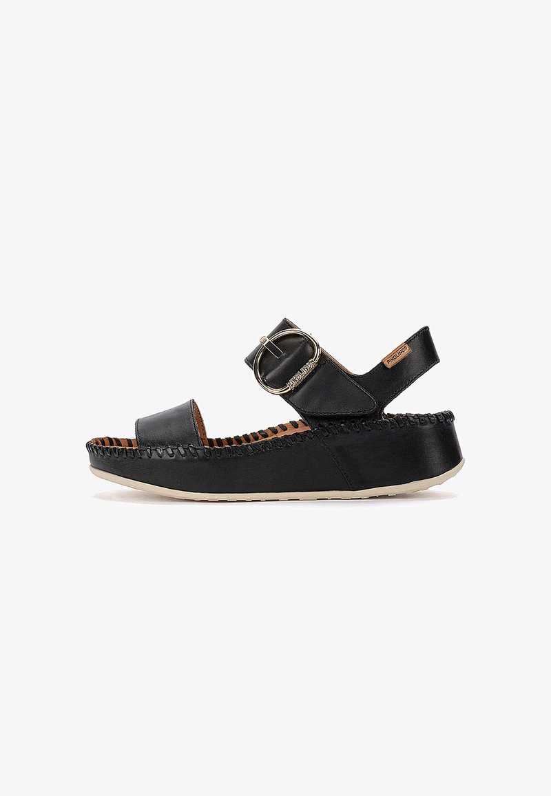 Sandale compensée en cuir noir avec bout ouvert, bride à boucle dorée réglable, semelle cousue et étiquette de marque sur la bride de la cheville.