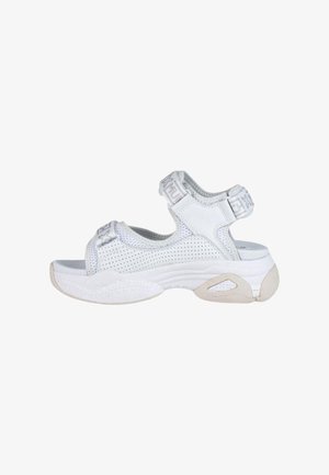 Las sandalias deportivas blancas presentan un diseño de malla, correas ajustables y una suela de goma gruesa con acentos texturizados para ofrecer agarre y soporte.