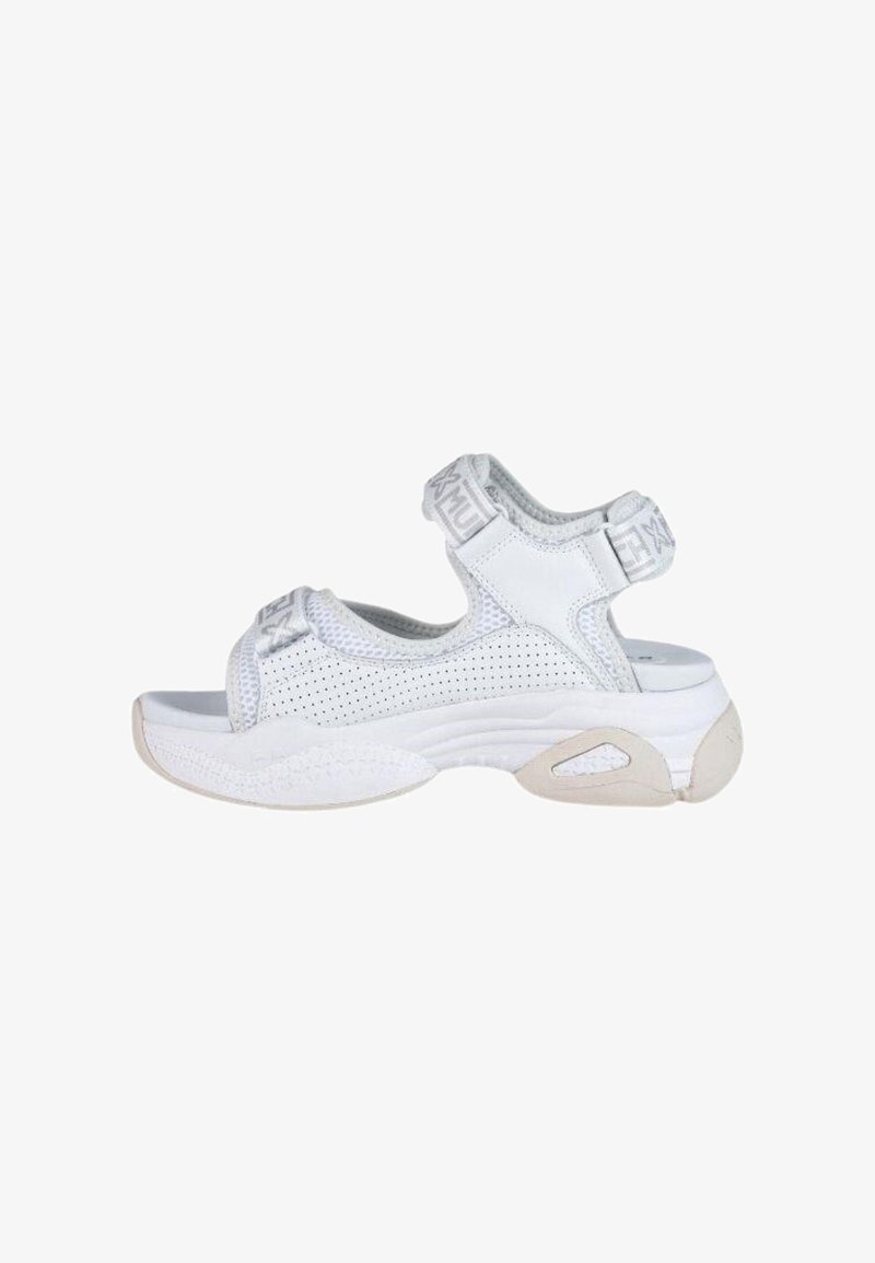 Las sandalias deportivas blancas presentan un diseño de malla, correas ajustables y una suela de goma gruesa con acentos texturizados para ofrecer agarre y soporte.