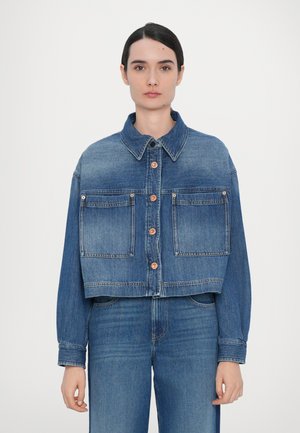 Lyhyt denim-takki keskimääräisen sinisen värisenä, jossa on napitettava etuosa, kaksi rintataskua ja klassinen kaulus. Pitkät hihat suoran leikkauksen kanssa.