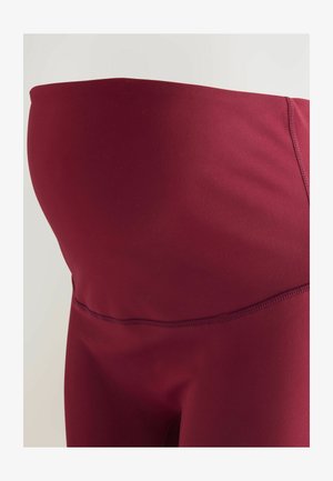 Tehotenské legíny z bordového elastického materiálu. Vybavené vysokým pásom, hladkou textúrou a plochými švami pre pohodlie a podporu.