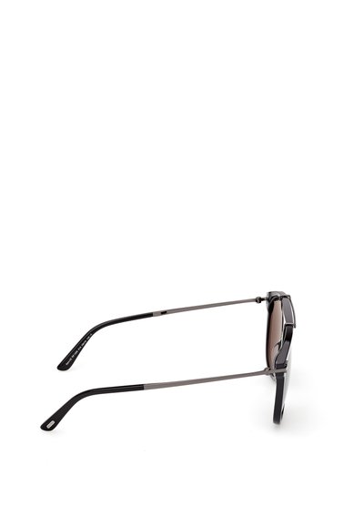 Gafas de sol con montura negra, lentes marrones degradados, brazos de metal y puntas texturizadas en negro. Presentan un diseño elegante y moderno.
