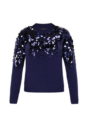 Un pull bleu marine à manches longues, présentant un dégradé de grandes paillettes brillantes noires et argentées sur la partie supérieure. Encolure et ourlet côtelés.
