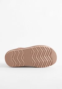 Platt, rosa gummisul med zickzackmönster, texturerad yta och något upphöjda kanter. Inga synliga varumärken eller detaljer.