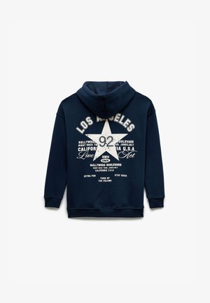 Marineblaues Sweatshirt mit Kapuze, das ein weißes Stern-Design und Text, darunter "LOS ANGELES" und "92," auf der Rückseite zeigt, mit gerippten Bündchen und Saum.
