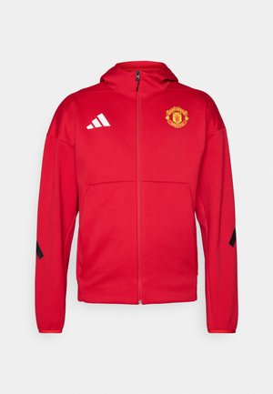 Red zip-up jacket made of soft material. Features a hood, Manchester United logo on the chest, and white Adidas stripes on the shoulders.