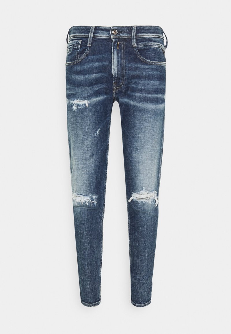 Jean slim bleu avec lavage délavé et déchirures usées sur les cuisses et les genoux, style cinq poches avec fermeture avant par bouton et fermeture éclair.