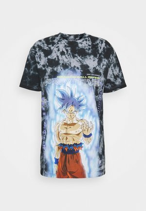 Lyhytnäyttöinen musta t-paita, jossa on tummasilkkinen värjäys ja Dragon Ball Super -grafiikka. Korostaa sinihiuksista hahmoa, jolla on lihaksikas rakenne, yksityiskohtaiset värit ja kuviot.
