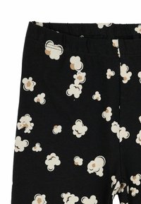 Juodos leggingai su baltu ir smėlio spalvos spragėsių raštu, pagaminti iš minkštos elastinės medžiagos, su elastinga juosmens juosta patogumui.