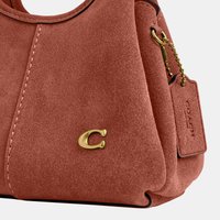 Sac à main en daim marron avec logo "C" doré et étiquette assortie attachée par une chaîne à billes dorée.