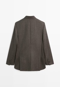 Blazer tailorato marrone scuro con colletto a punta, spacco posteriore singolo e polsini con bottoni. Realizzato in un tessuto misto lana texturizzato.