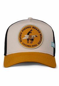 Trucker cap with a beige front, black mesh sides, and a yellow visor. Features an embroidered circular patch with a llama and text.