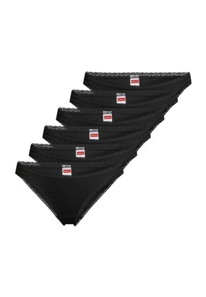 Kuusi mustaa pitsireunuksilla varustettua naisten alkkaria pinossa, joissa kunkin vyötärönauhan keskellä on valkoinen ja punainen merkkilappu.