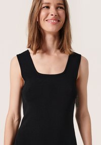 Top sans manches noire avec un décolleté carré, fabriqué en tissu texturé. Présente une silhouette ajustée et une couleur lisse, uniforme, sans motifs.