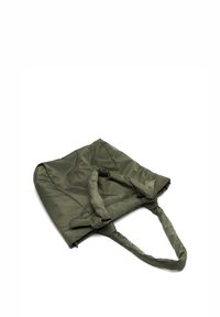 Oliivivihreä kangaskassi, joka on valmistettu kestävästä kankaasta. Kassi on varustettu kahdella pitkällä kahvalla, siinä on pehmeä rakenne ja hieman löysä muotoilu.