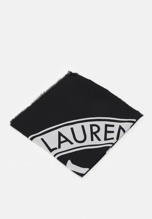 Carré de tissu plié noir et blanc avec bords effilochés et texte partiel "LAUREN" visible sur un fond uni.