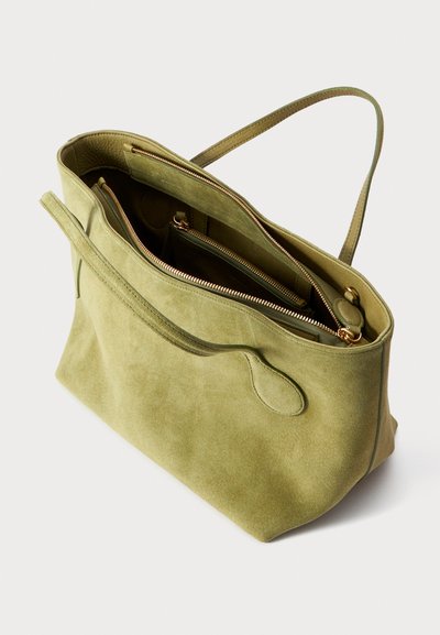 Geantă tote din suede verde, cu două fermoare superioare, compartimente interioare și un singur mâner. Textură moale cu detalii de design minimaliste.