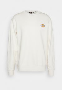 Sweat-shirt blanc à manches longues avec col rond, petit logo rond Dickies sur la poitrine gauche, poignets et ceinture côtelés.