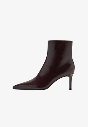 Bottine en cuir bordeaux avec un bout pointu, un design épuré et un haut talon aiguille. Texture lisse avec un discret grain.