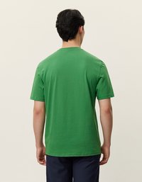Groene katoenen t-shirt met korte mouwen, ronde hals en een eenvoudig ontwerp. De stof lijkt zacht en glad. Geen opvallende patronen of kenmerken.