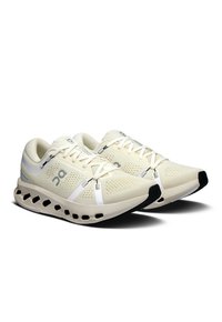 Chaussures de course légères avec une tige crème, en matériau en maille, semelle extérieure noire, et rehaussées de détails argentés et d'un système de laçage.