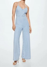 Un mono de mezclilla azul claro con tirantes finos, un cuerpo ajustado, diseño de pierna ancha y una costura de cintura definida. Construcción sencilla, sin patrones.