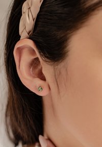 Grüne Edelstein-Ohrringe in Stud-Form präsentieren ein florales Design mit kleinen runden und marquiseförmigen Steinen. Sie sind in einer schlichten Metallbasis gegen die Haut eingefasst.