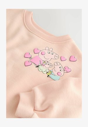 Svijetlo ružičasta dukserica s razigranim dizajnom koji prikazuje tri karikaturalne svinje i srca. Mekana tkanina s rebrastim izrezom i rukavima.