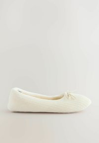Ballet flats en tissu blanc avec une texture côtelée, un bout arrondi et un petit nœud décoratif à l'avant. Matériau doux, design simple.